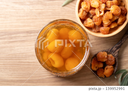 Longan juice in glass with dried longan fruit on wooden background Longan juice in glass with dried longan fruit on wooden background 139952991