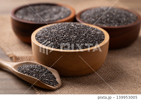 Healthy organic chia seeds in a wooden bowl and scoop. Superfood for a balanced diet and weight loss Healthy organic chia seeds in a wooden bowl and scoop. Superfood for a balanced diet and weight loss 139953005