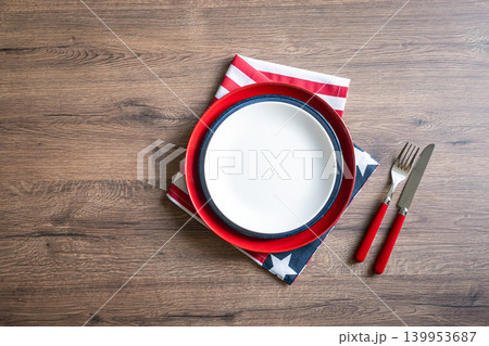 Patriotic table setting with empty white plate and american flag napkin on wooden background Patriotic table setting with empty white plate and american flag napkin on wooden background 139953687