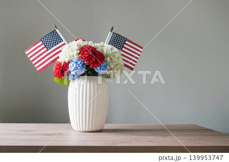 Patriotic flower bouquet with American flags in white vase on table Patriotic flower bouquet with American flags in white vase on table 139953747
