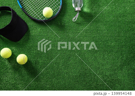Tennis accessories flat lay on green grass with copy space Tennis accessories flat lay on green grass with copy space 139954148