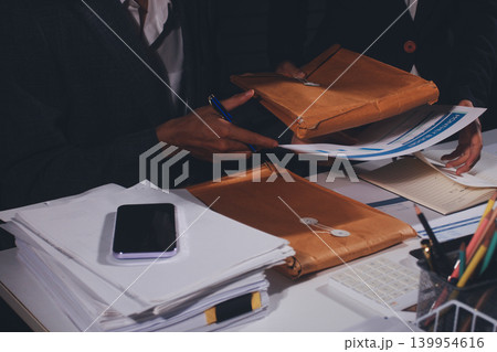 Professional photo of a person's hands reviewing a contract or legal document on a desk, for concepts of business, finance, and legal affairs Professional photo of a person's hands reviewing a contract or legal document on a desk, for concepts of business, finance, and legal affairs 139954616