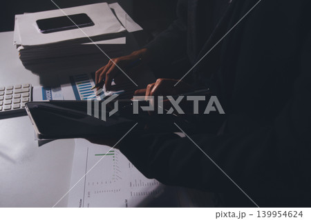 Professional photo of a person's hands reviewing a contract or legal document on a desk, for concepts of business, finance, and legal affairs Professional photo of a person's hands reviewing a contract or legal document on a desk, for concepts of business, finance, and legal affairs 139954624