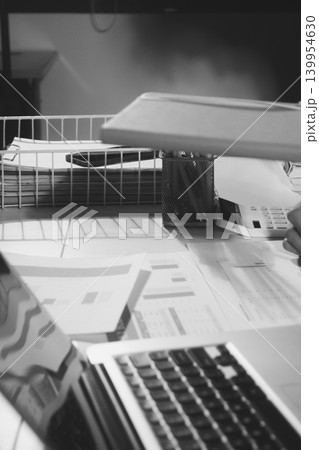 Professional photo of a person's hands reviewing a contract or legal document on a desk, for concepts of business, finance, and legal affairs 139954630