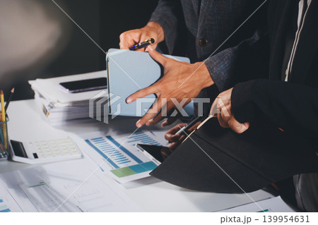 Professional photo of a person's hands reviewing a contract or legal document on a desk, for concepts of business, finance, and legal affairs Professional photo of a person's hands reviewing a contract or legal document on a desk, for concepts of business, finance, and legal affairs 139954631