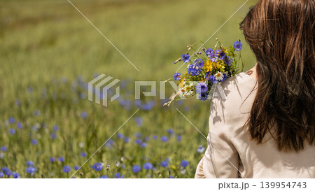 Woman with Wildflower Bouquet in Cornflower Field 139954743
