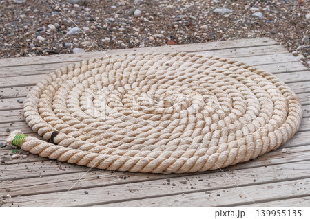 Folded vintage sea rope lies on seashore. Marina seascape. 139955135