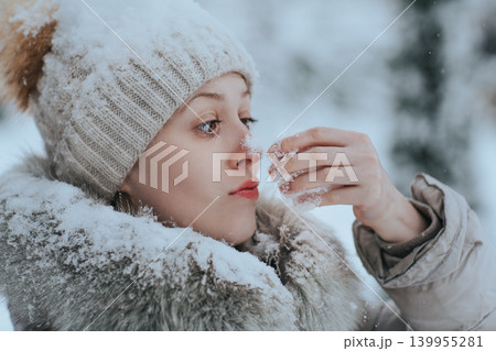 Portrait of a funny woman in warm winter clothing with snow Portrait of a funny woman in warm winter clothing with snow 139955281