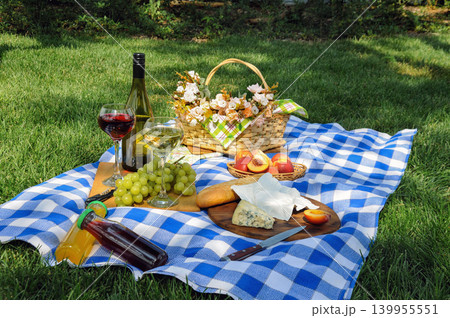 Summer picnic on green grass with wine, grapes, cheese and peaches Summer picnic on green grass with wine, grapes, cheese and peaches 139955551
