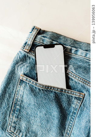 Smartphone with blank screen in a blue denim jeans pocket 139956063