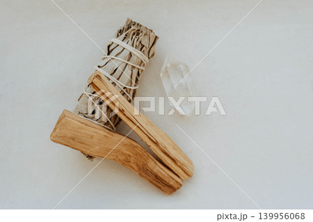 White sage bundle, palo santo stick and clear quartz crystal on light background 139956068