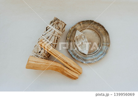 White sage bundle, palo santo stick and clear quartz crystal on light background 139956069