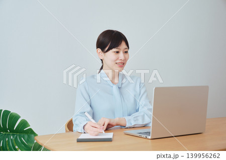 ノートを取りながらオンラインで仕事をする女性 ノートを取りながらオンラインで仕事をする女性 139956262