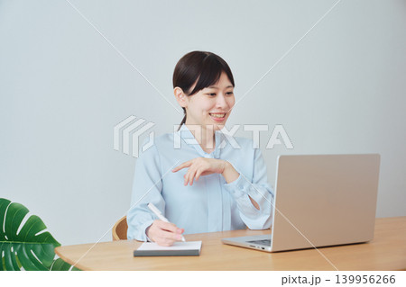 ノートを取りながらオンラインで仕事をする女性 ノートを取りながらオンラインで仕事をする女性 139956266