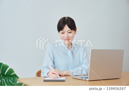 在宅で仕事をしながら笑顔を見せる女性 在宅で仕事をしながら笑顔を見せる女性 139956267