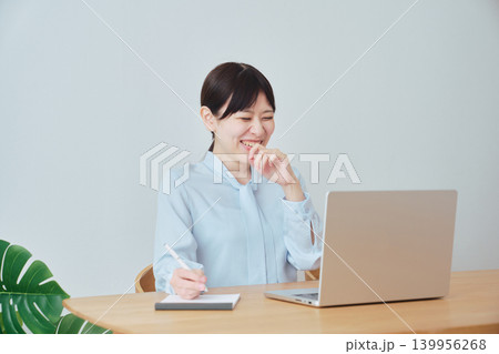 在宅で仕事をしながら笑顔を見せる女性 在宅で仕事をしながら笑顔を見せる女性 139956268