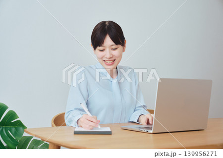 ノートを取りながらオンラインで仕事をする女性 ノートを取りながらオンラインで仕事をする女性 139956271