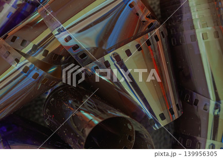 Abstract Colorful Film Strips Close Up. Close-up of vintage translucent film strips, light reflections, dark cinematic tones. Abstract media image for cinema, photography, archival, creative projects 139956305
