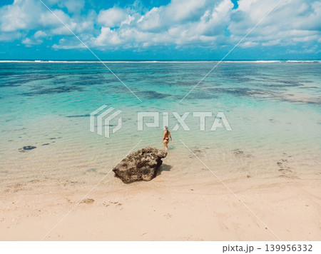 Woman standing in crystal clear water in tropical ocean lagoon Woman standing in crystal clear water in tropical ocean lagoon 139956332