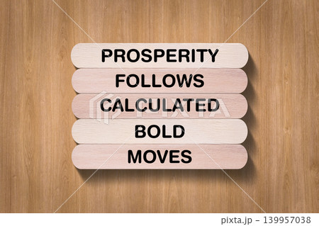 Prosperity Follows Calculated Bold Moves tagline written on wooden stick with wooden texture background, business and investment, stock market theme, copy space Prosperity Follows Calculated Bold Moves tagline written on wooden stick with wooden texture background, business and investment, stock market theme, copy space 139957038