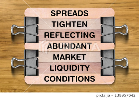 Spreads Tighten Reflecting Abundant Market Liquidity Conditions tagline written on wooden stick hold by binder clip with wooden texture background, business and investment, stock market theme Spreads Tighten Reflecting Abundant Market Liquidity Conditions tagline written on wooden stick hold by binder clip with wooden texture background, business and investment, stock market theme 139957042