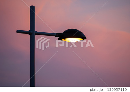 Street Lamp Lit at Sunset in Urban Setting Street Lamp Lit at Sunset in Urban Setting 139957110