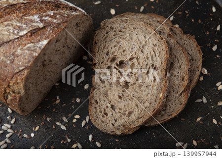 Sliced Sunflower Seed Bread Presentation. Artisan Sunflower Seed Bread on Rustic Surface. Sliced Sunflower Seed Bread Presentation. Artisan Sunflower Seed Bread on Rustic Surface. 139957944