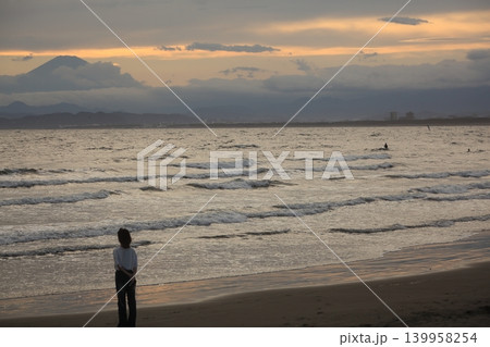 湘南海岸の夕焼けを見つめる女性 139958254