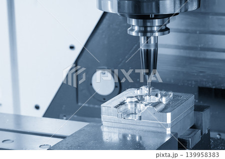 Close-up of a small ball nose end mill tool high-precision cutting mold parts on a CNC milling machine in a blue-toned industrial scene. Close-up of a small ball nose end mill tool high-precision cutting mold parts on a CNC milling machine in a blue-toned industrial scene. 139958383
