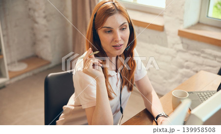Female support agent coordinating client tasks during office workday Female support agent coordinating client tasks during office workday 139958508
