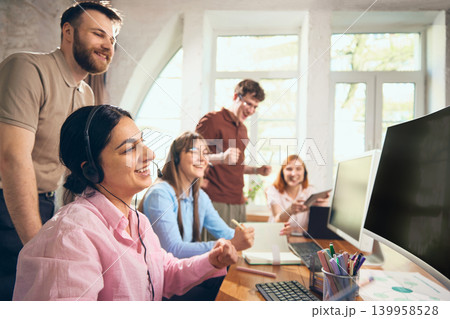 Happy customer support team celebrating successful result in office. 139958528