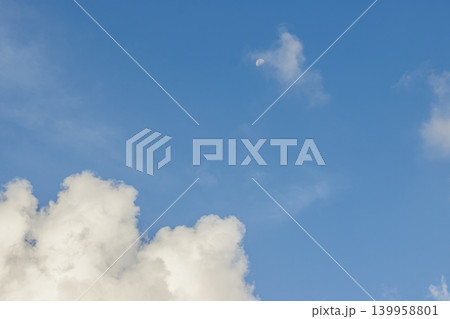 Moon and Clouds in Blue Sky. Nature Background. Celestial Cloudscape. Peaceful Scene. Daylight Weather. High quality photo Moon and Clouds in Blue Sky. Nature Background. Celestial Cloudscape. Peaceful Scene. Daylight Weather. High quality photo 139958801