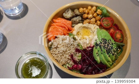 close up of healthy meal for diet colourful grain salad bowl with avocado, salmon, carrot slice, beetroot, chickpeas, quinoa, and fresh vegetables for balanced meal with copy space and pestle sauce close up of healthy meal for diet colourful grain salad bowl with avocado, salmon, carrot slice, beetroot, chickpeas, quinoa, and fresh vegetables for balanced meal with copy space and pestle sauce 139959304