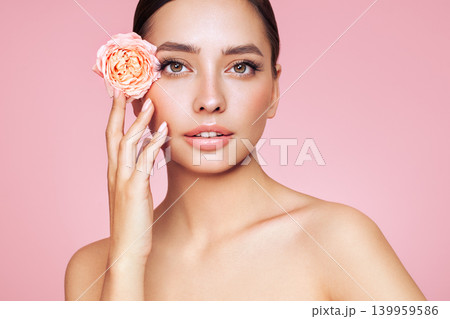 Beautiful young woman with a rose flower 139959586