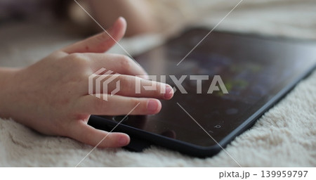 Close-up finger scrolling social media. Girl browsing digital tablet computer. The problem of addiction to gadgets. 139959797