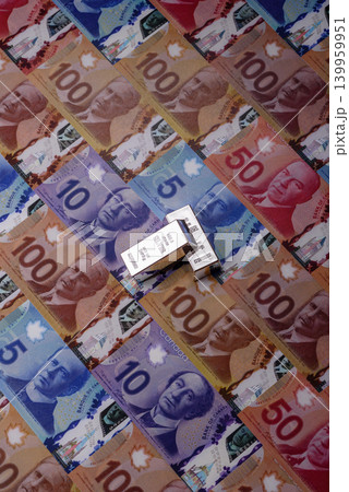 A silver bar, white metal against a backdrop of Canadian money, as a concept. A silver bar A silver bar, white metal against a backdrop of Canadian money, as a concept. A silver bar 139959951