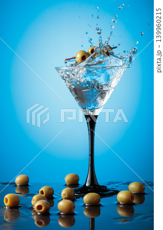 Martini with green olives on a wet table. Martini with green olives on a wet table. 139960215