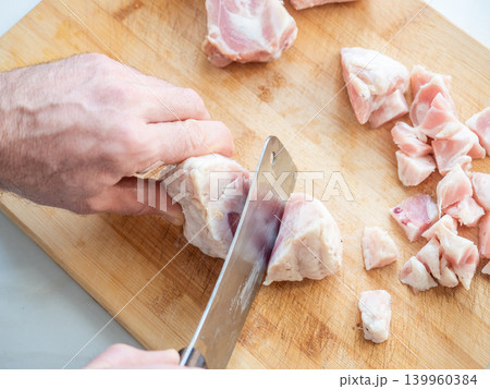Man cutting turkey and chicken meat on wooden cutting board Man cutting turkey and chicken meat on wooden cutting board 139960384