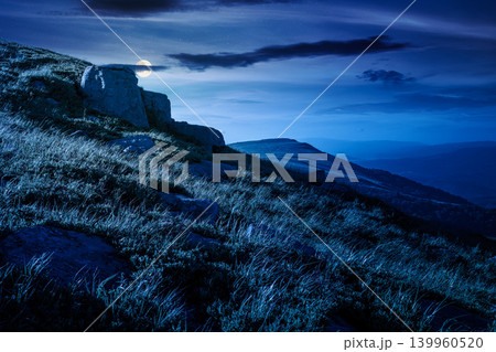 mountain landscape in summer at night. mysterious outdoor scenery of carpathian mountains. full moon over grassy slopes with rocks. fantasy image for ukraine travel background 139960520