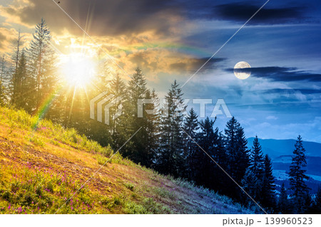 day meet night. view of a hillside of mountain range with coniferous forest and meadow. sun and moon over mountain landscape in summer at twilight. nice picture for earth day or astrology background 139960523