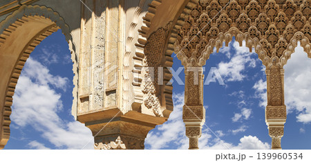 Arches in Islamic (Moorish) style (against the background of a beautiful sky with clouds) in Alhambra, Granada, Spain 139960534