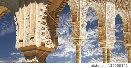Arches in Islamic (Moorish) style (against the background of a beautiful sky with clouds) in Alhambra, Granada, Spain 139960541