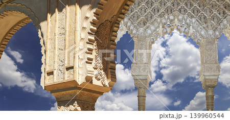 Arches in Islamic (Moorish) style (against the background of a beautiful sky with clouds) in Alhambra, Granada, Spain Arches in Islamic (Moorish) style (against the background of a beautiful sky with clouds) in Alhambra, Granada, Spain 139960544