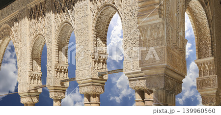 Arches in Islamic (Moorish) style (against the background of a beautiful sky with clouds) in Alhambra, Granada, Spain Arches in Islamic (Moorish) style (against the background of a beautiful sky with clouds) in Alhambra, Granada, Spain 139960560