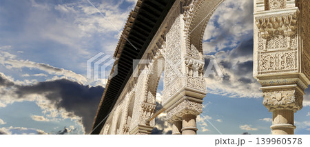 Arches in Islamic (Moorish) style (against the background of a beautiful sky with clouds) in Alhambra, Granada, Spain Arches in Islamic (Moorish) style (against the background of a beautiful sky with clouds) in Alhambra, Granada, Spain 139960578