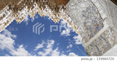 Arches in Islamic (Moorish) style (against the background of a beautiful sky with clouds) in Alhambra, Granada, Spain Arches in Islamic (Moorish) style (against the background of a beautiful sky with clouds) in Alhambra, Granada, Spain 139960720