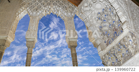 Arches in Islamic (Moorish) style (against the background of a beautiful sky with clouds) in Alhambra, Granada, Spain 139960722