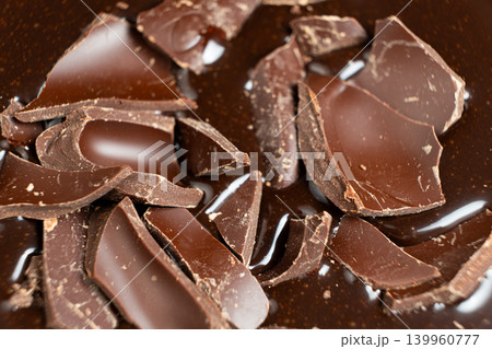 Dark chocolate chunks into liquid melted chocolate sauce background 139960777