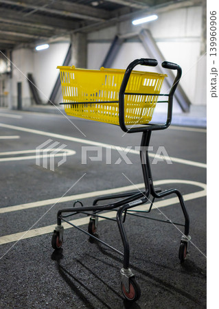 屋内駐車場に置かれた黄色いショッピングカート 屋内駐車場に置かれた黄色いショッピングカート 139960906