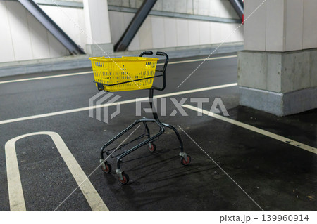 屋内駐車場に置かれた黄色いショッピングカート 屋内駐車場に置かれた黄色いショッピングカート 139960914